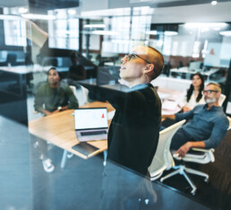 Young businesswoman giving a presentation to her colleagues. Creative young businesswoman presenting significant data in a boardroom. Group of modern businesspeople attending a briefing.