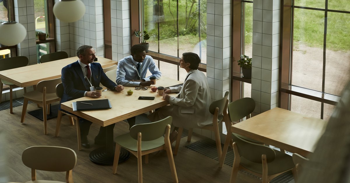 Two professionals in conversation over coffee about a new advisory practice